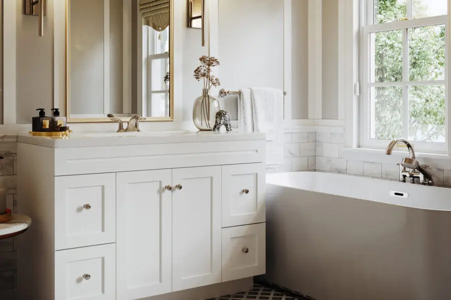 Modern bathroom with a white vanity, freestanding bathtub, marble backsplash, and natural light from a large window.