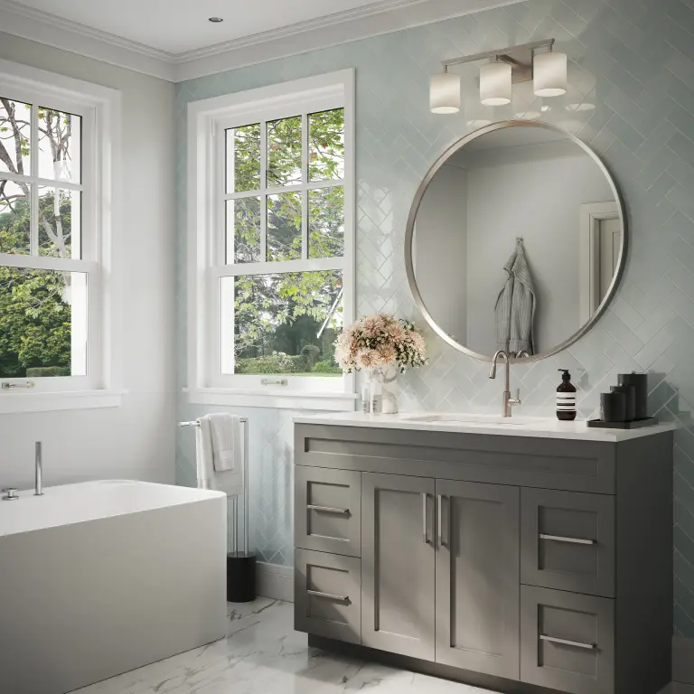 Elegant bathroom with a round mirror, gray vanity, and natural light through large windows.