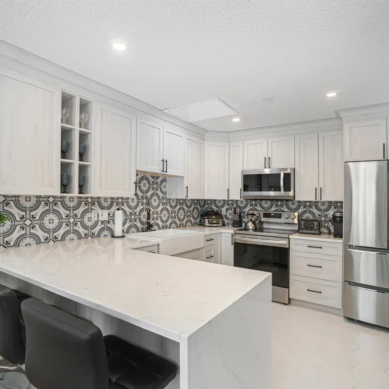 Sleek kitchen design with gray cabinets, metallic fixtures, and a geometric tile backsplash.